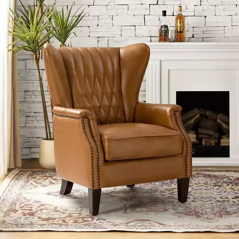 Fauteuil à oreilles en cuir véritable avec clous décoratifs et pieds fuselés en bois massif
