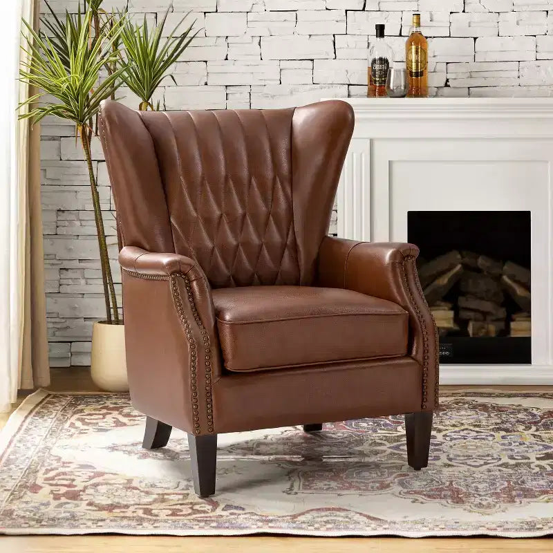 Fauteuil à oreilles en cuir véritable avec clous décoratifs et pieds fuselés en bois massif
